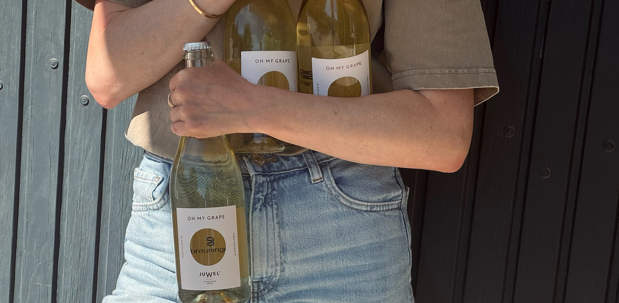 Juliane hält OH MY GRAPE Flaschen mit Breuninger Logo